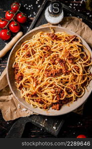 Homemade spaghetti bolognese in a plate on the table. Against a dark background. High quality photo. Homemade spaghetti bolognese in a plate on the table.