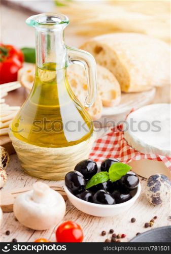 Homemade spaghetti pasta with quail eggs with botle of olive oil and cheese on wooden background. Classic italian village food. Garlic, black and green olives, oil and bread.