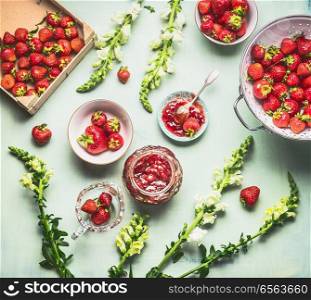 Homemade strawberries jam on kitchen table background with ingredients, top view, flat lay. Summer berries preserve concept. Seasonal local organic food