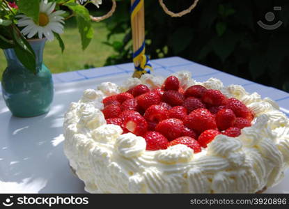 Homemade strawberry cake at a decorated table in a garden