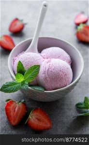 Homemade strawberry  ice cream with fresh strawberries. Sweet berry summer dessert. Concrete background