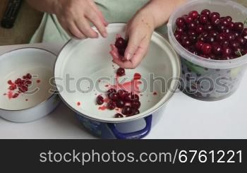 Homemade sweet cherry jam recipe - woman removes the pits from cherries timelapse
