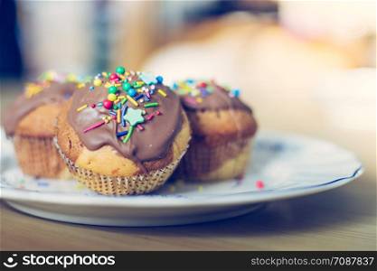 Homemade sweet cupcakes on a plate with colourful decoration