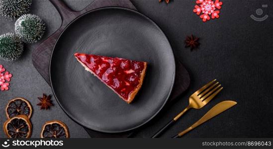 Homemade tasty cheesecake with jelly and raspberry berries on a black plate on a dark concrete background. Homemade tasty cheesecake with jelly and raspberry berries on a black plate