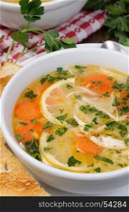 Homemade, tender soup with chicken, lemon, orzo, and fresh parsley leaves