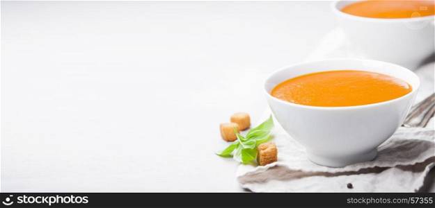 Homemade tomato cream soup in bowls (or gazpacho) over concrete background