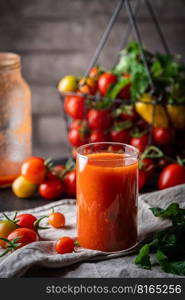 Homemade Tomato juice with fresh celery in glass with fresh cherry tomato on a wooden table.. Homemade Tomato juice