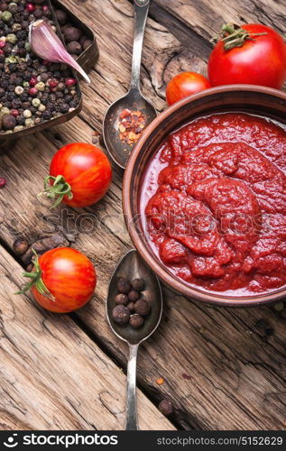 homemade tomato sauce. Spicy tomato ketchup on an old wooden table