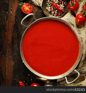 Homemade Tomato soup on wooden table, top view