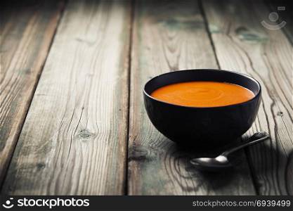 Homemade tomato soup (or gazpacho) over old wooden background