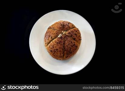 Homemade Truffle Cream Cheese Bun on white ceramic plate in black background. The concept of delicious food, Top view, Space for text, Selective Focus.
