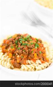 Homemade vegan bolognese sauce made with soy meat, fresh tomatoes, onion and garlic served on fusilli pasta and sprinkled with parsley (Selective Focus, Focus one third into the image). Vegan Soy Meat Bolognese Sauce on Pasta
