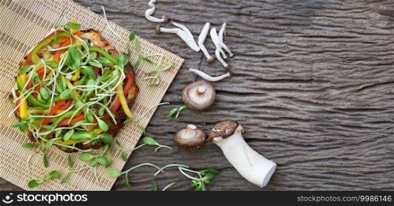  Homemade vegetarian pizza with sunflower sprout and mushroom on a wooden table background