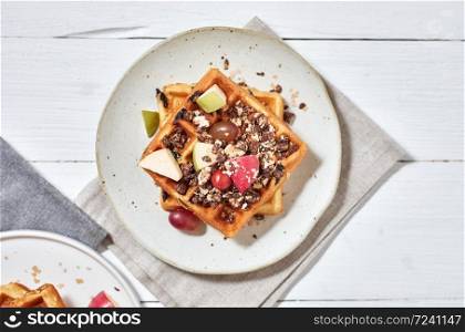 Homemade waffles with fruit and granola.