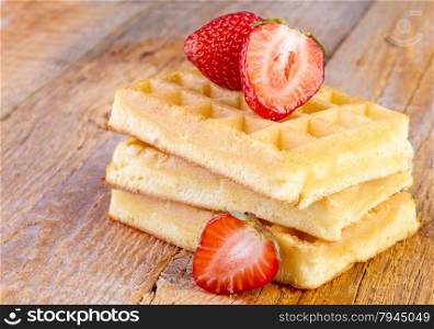 homemade waffles with strawberries on wooden background