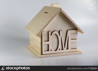 Homemade wooden house piggy bank with the inscription home. House on a solid background.. Homemade wooden house piggy bank with the inscription home