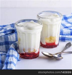 homemade yogurt with jam in a glass jar on a wooden table