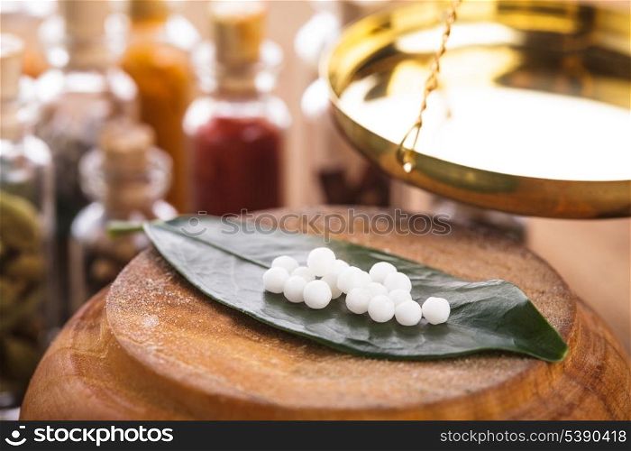 Homeopathy pills on the green leaf closeup