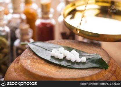 Homeopathy pills on the green leaf closeup