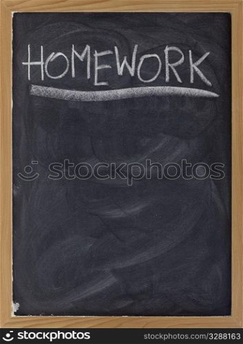homework word handwritten with white chalk on blackboard with strong texture and smudge patterns, copy space below