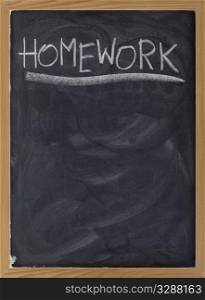 homework word handwritten with white chalk on blackboard with strong texture and smudge patterns, copy space below