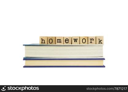 homework word on wood stamps stack on books, school and assignment concepts