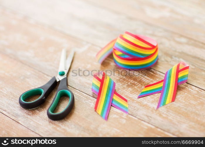 homosexual and lgbt concept - gay awareness ribbon and scissors on wooden boards. gay awareness ribbon and scissors on wooden boards. gay awareness ribbon and scissors on wooden boards