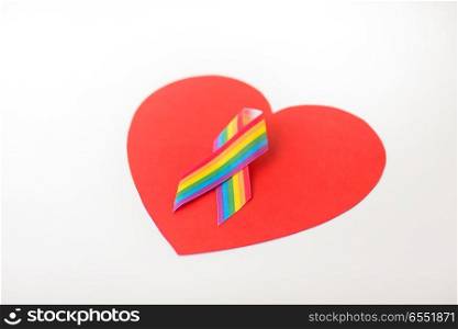 homosexual and lgbt concept - gay pride awareness ribbon on red heart shape over white background. gay pride awareness ribbon on red heart. gay pride awareness ribbon on red heart