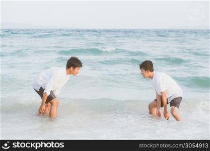 Homosexual portrait young asian couple play water on beach with cheerful together in summer, tourism of asia gay fun for leisure and relax with happiness in vacation at sea, LGBT legal concept.