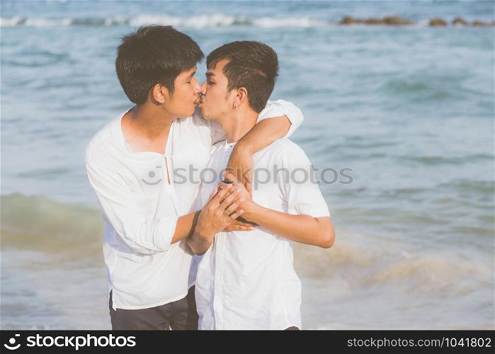 Homosexual portrait young asian couple standing hug and kiss mouth together on beach in summer, asia gay going tourism for leisure with romantic and happiness in vacation at sea, LGBT legal concept.