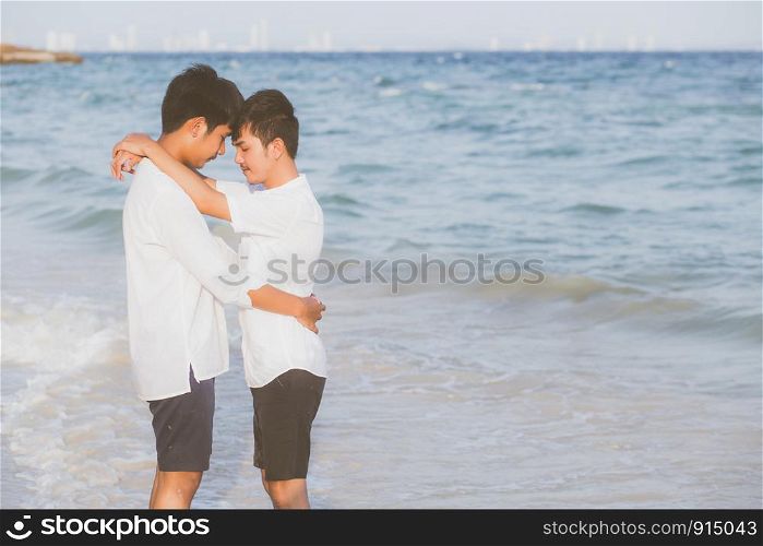 Homosexual portrait young asian couple standing hug together on beach in summer, asia gay going tourism for leisure and relax with romantic and happy in vacation at sea, LGBT legal concept.