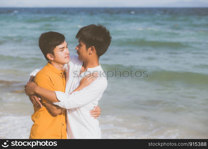 Homosexual portrait young asian couple standing hug together on beach in summer, asia gay going tourism for leisure and relax with romantic and happiness in vacation at sea, LGBT concept.