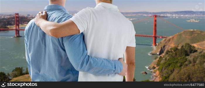 homosexual relationships, same-sex marriage and lgbt concept - close up of happy male gay couple hugging over golden gate bridge in san francisco bay background. close up of gay couple over golden gate bridge. close up of gay couple over golden gate bridge