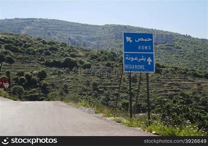 Homs; road sign; war; syria; city; middle; people; east; scene; urban; ethnicity; eastern; outdoors; politics; islam; land; horizontal; conflict; poverty; man; border; international; arabia; emigration; waiting; transportation; immigration; europe; travel; made; structure; women; immigrant; child; building; syrian; retro; construction; arabic; baby; backgrounds; map; Homs road sign in Syria