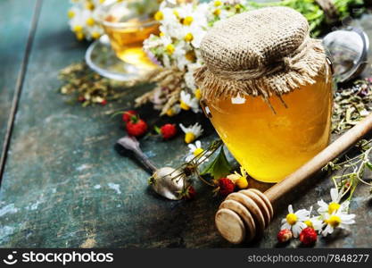 Honey and Herbal tea on wooden background - summer, health and organic food concept
