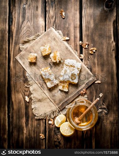 Honey background. Natural honey lemon slices and walnuts. On wooden background.. Honey background. Natural honey lemon slices and walnuts.