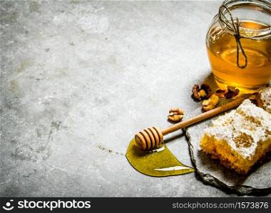 Honey background. Natural sweet honey with shelled walnuts. On the stone table.. Honey background. Natural sweet honey with shelled walnuts.
