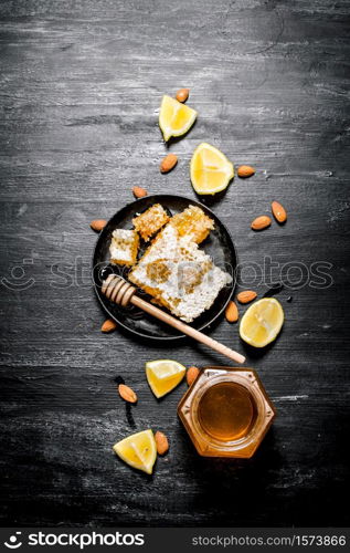 Honey background. Sweet natural honey with lemon . On black rustic background.. Honey background. Sweet natural honey with lemon .
