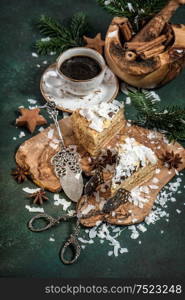Honey cake with Christmas decoration and cup of coffee on dark background. Festive sweet food. Vintage style toned picture
