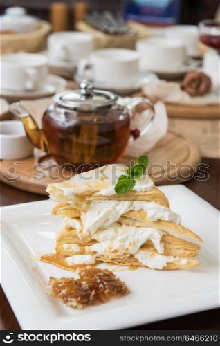 Honey cake with vanilla cream. Honey cake with vanilla cream at white plate