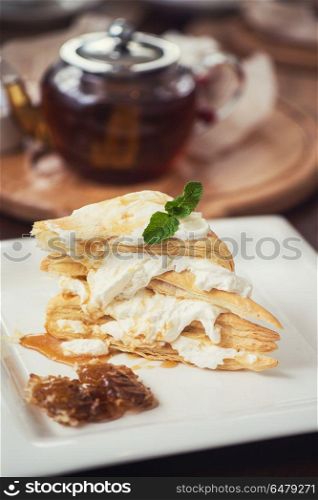 Honey cake with vanilla cream. Honey cake with vanilla cream at white plate