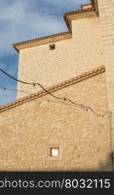 Honey-colored stone masonry on large buildings in the center of Binissalem, Majorca, Spain.