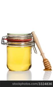 honey covered honey dipper leaning at a honey jar. honey covered honey dipper leaning at a honey jar on white background