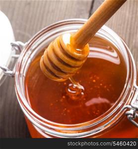 Honey drip in jar on the table