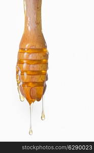 Honey dripping from a wooden honey dipper