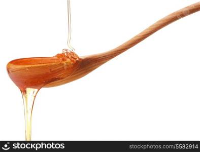 Honey dripping from a wooden honey dipper isolated on white background cutout