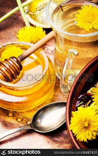 Honey from dandelion flowers. Honey from a blooming spring dandelion and cup of tea