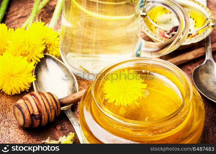 Honey from dandelion flowers. Honey from a blooming spring dandelion and cup of tea