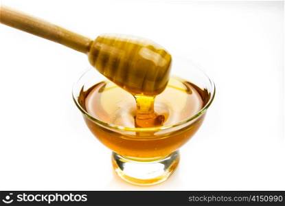honey in a glass bowl with a wooden stick