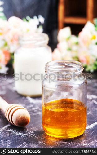 honey in glass bank and milk on a table